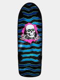 A Powell Peralta skateboard deck featuring a black background with blue and green wavy stripes, a pink torn-paper effect, and a white skull graphic with green eyes.