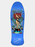 A blue skateboard deck featuring a colorful graphic of a woman in a red wig standing in front of a heart-shaped cauldron, with the brand name 'SNURB' at the top and 'Skateboards' at the bottom.