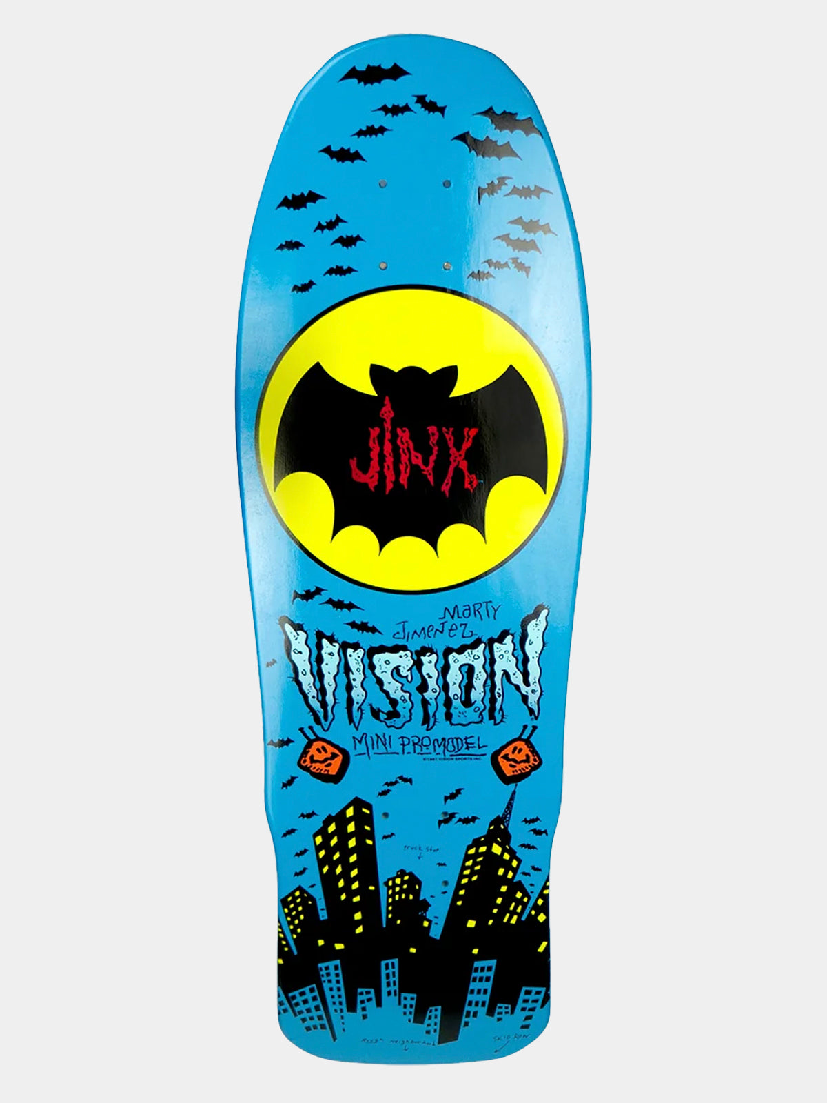 A blue skateboard deck featuring a Batman-themed graphic design with a large yellow bat logo containing the red text 'JINX', the word 'VISION' in stylized white lettering, and a black city skyline at the bottom.